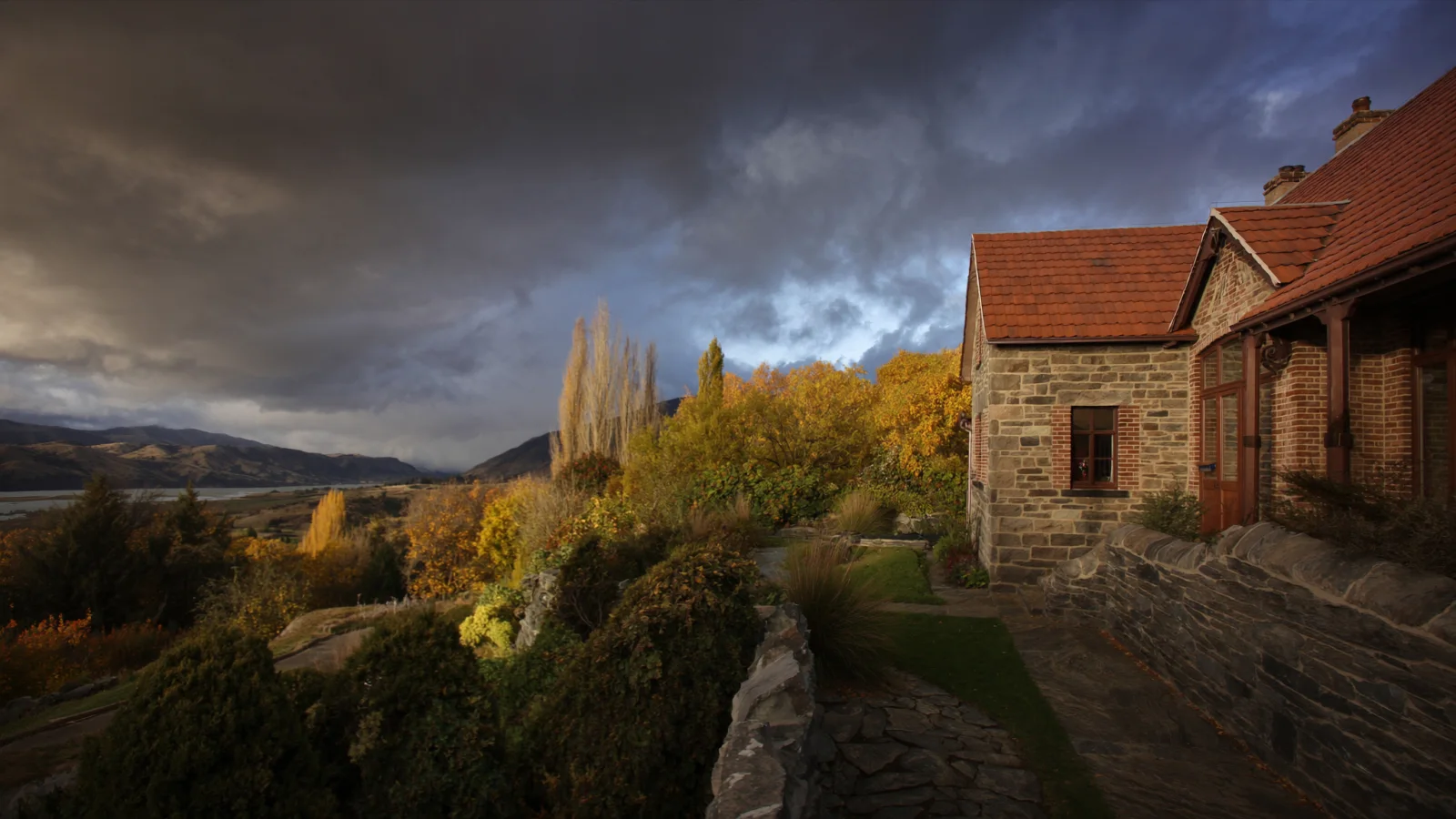 Editorial concept of a restored Arrowtown cottage among autumn trees